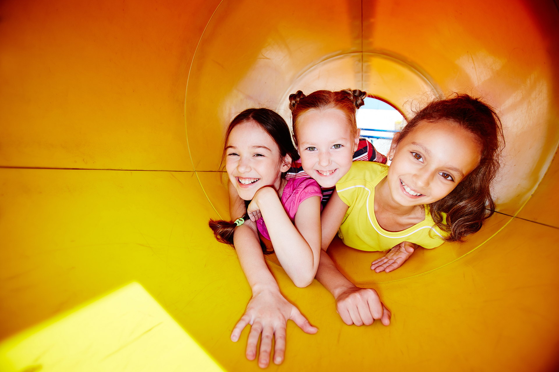 Happy little girls looking at camera while enjoying leisure